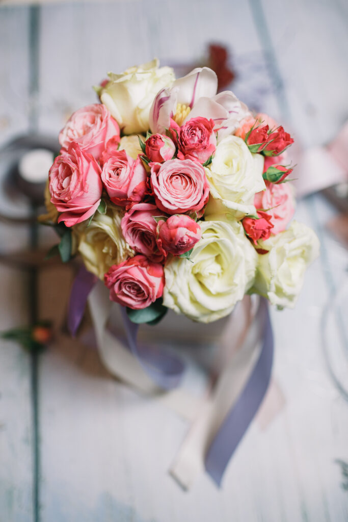 Box with white and orange bouquet stands on florist's working table