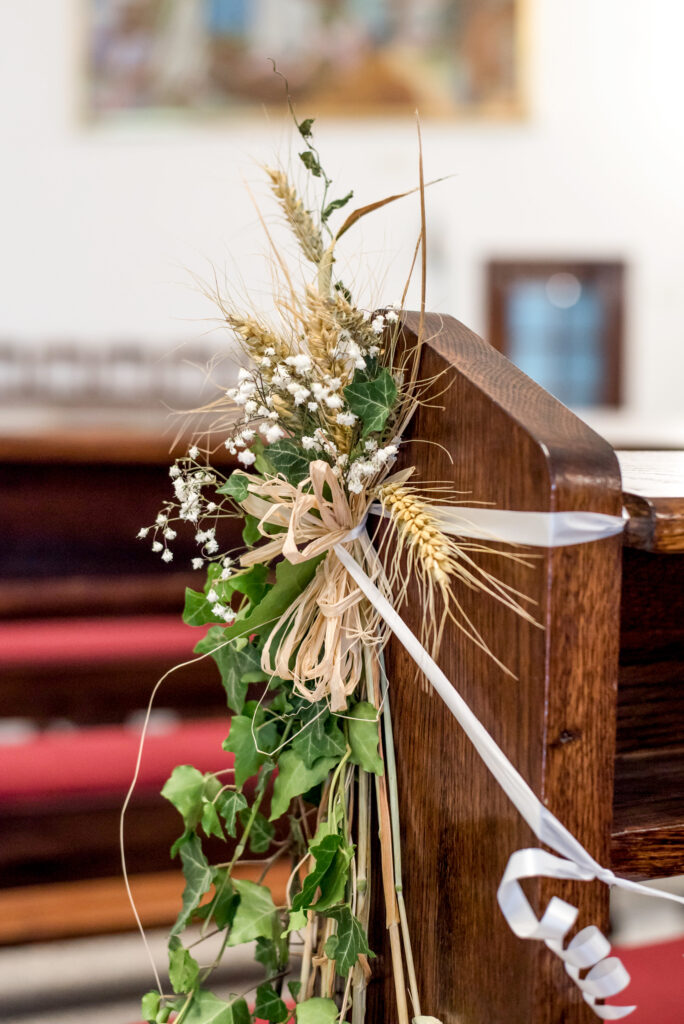 A vertical closeup shot of decorative plants on a wooden wedding chair